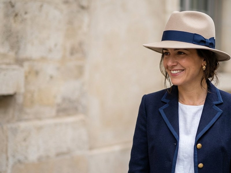 A felt hat with a navy grosgrain hat band, worn with a navy jacket